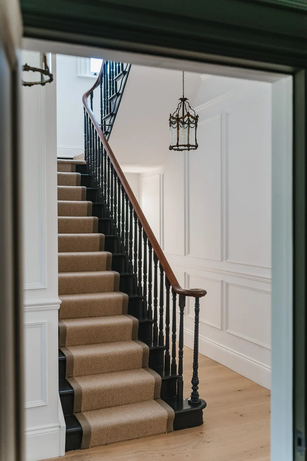 Restored staircase with dark balustrade in a NOOR renovation
