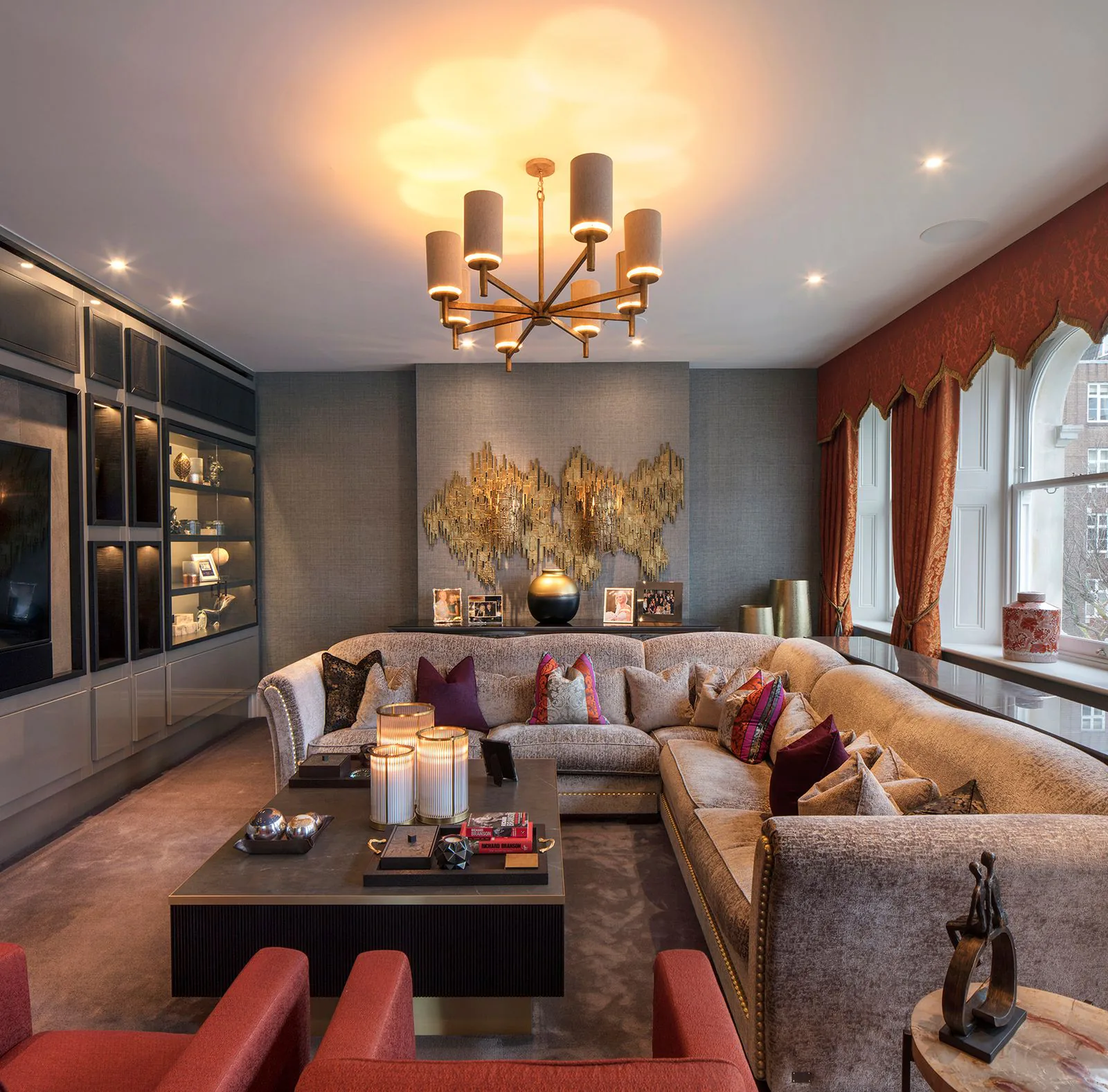 Elegant media room with brass chandelier finished by NOOR